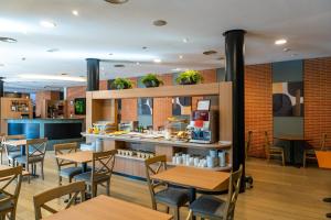 a restaurant with wooden tables and chairs and a counter at Posadas de España Pinto in Pinto