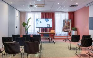 a meeting room with chairs and a projection screen at ibis Lille Centre Gares in Lille