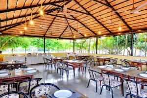 a dining room with tables and chairs in a building at Royal Garden Brindavan Resort in Hosa Kannambādi