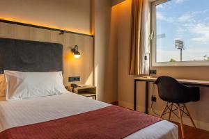 a hotel room with a bed and a chair and a window at Posadas de España Pinto in Pinto +61 photos
