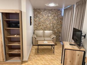 a living room with a couch and a television at Crystal Hotel By FHM in Aqaba