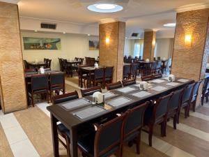 a dining room with a long table and chairs at Crystal Hotel By FHM in Aqaba