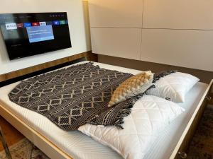 a bed with a blanket and pillows in a room at TUGENDHAT Boutique Suite in Komárov