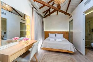 a bedroom with a bed and a desk and a tub at Panellinion Luxury Rooms in Kalamata +181 photos