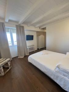 a bedroom with a large white bed and a table at Olbia City Hotel & Spa in Olbia