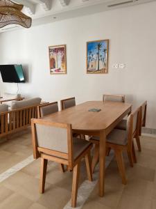 a wooden dining room table with chairs and a couch at Dar Lisa - Charming authentic beachfront villa in Aghīr