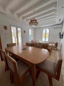 a dining room with a wooden table and chairs at Dar Lisa - Charming authentic beachfront villa in Aghīr