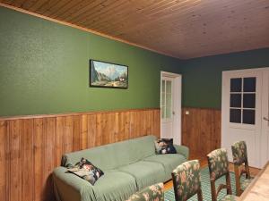 a living room with a green couch and chairs at Large detached house without neighbors in Kouvola