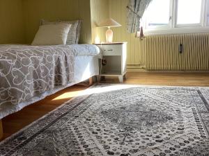 a bedroom with a bed and a rug on the floor at Angelas White House - single room in Stamsund