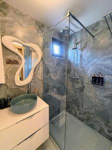 a bathroom with a glass shower with a sink at Yatak in Vatra Dornei