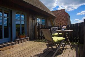 a wooden deck with a table and a chair at Dreiurtshof Fewo 2 in Remplin