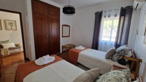a hotel room with two beds and a couch at Serenity Villa in Porches +14 photos