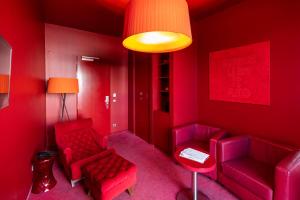 a red room with two red chairs and a lamp at ARCOTEL Rubin Hamburg in Hamburg