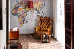 a room with a chair and a map of the world at ARCOTEL Rubin Hamburg in Hamburg