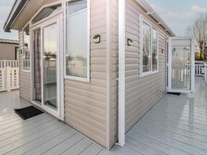 a house with a door and windows on a deck at Plot 243 - Coldingham Bay Leisure Park in Eyemouth