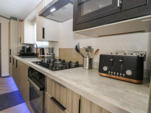 a kitchen with a stove and a counter top at Plot 243 - Coldingham Bay Leisure Park in Eyemouth
