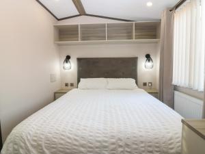 a bedroom with a large white bed with two lights at Plot 243 - Coldingham Bay Leisure Park in Eyemouth