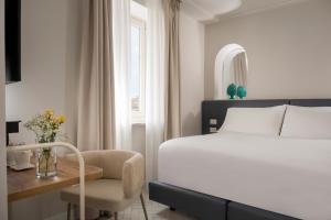 a bedroom with a bed and a desk and a chair at Palazzo Tasso in Sorrento +82 photos