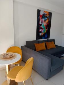 a living room with a couch and a table with chairs at Apartamentos El Velero in Torremolinos +33 photos