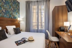 a hotel room with a bed with a hat on it at Hotel Khla Nice in Nice +96 photos