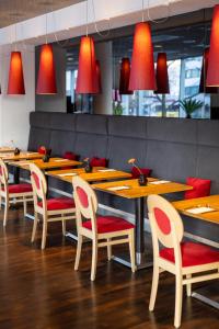 a restaurant with wooden tables and chairs and red lights at ARCOTEL Rubin Hamburg in Hamburg