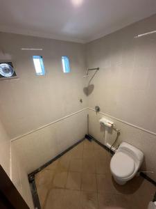 a bathroom with a toilet and two windows at Muno House in Seminyak