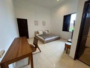 a room with a table and a bed in it at Muno House in Seminyak