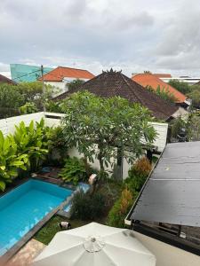 an overhead view of a swimming pool with an umbrella at Muno House in Seminyak