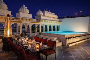 a restaurant with a swimming pool in a building at Chunda Haveli - A Heritage Hotel Near City Palace Udaipur in Udaipur