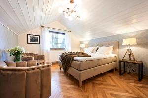 a bedroom with a bed and a chair and a window at Bottengarn Boutique Guesthouse - Farm in Igaküla