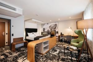 ein Hotelzimmer mit Bett und Schreibtisch in der Unterkunft Hotel Global Inn in Wolfsburg