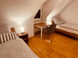 a room with a bed and a desk with a chair at Giebelglück - 3 Zimmer, direkt an der UniKlinik, 2 Schlafzimmer, 4 Gäste, WLAN in Würzburg