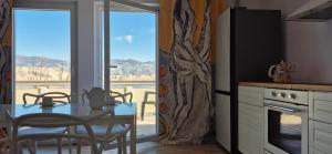 a kitchen with a table and chairs and a balcony at Seaview family apartments Dubrava in Pag