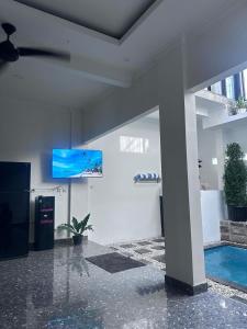 a living room with a tv and a swimming pool at Villa Manis in Denpasar