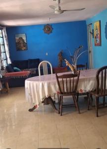 a dining room with a table and chairs and a blue wall at Finca EL CHACHALACO in Agua Buena