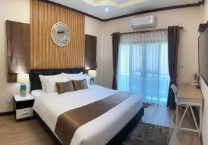 a bedroom with a bed and a desk and a window at Malinee Villa Phuket in Bang Tao Beach