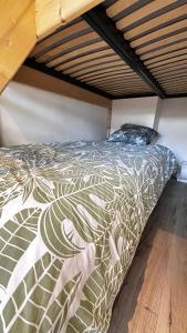 a bed with a comforter on it in a room at Appartement T1bis Saint Herblain in Saint-Herblain