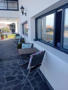 a patio with chairs and tables and windows at Surf & Guest Lorena´s House in Ribeira Grande +40 photos