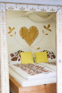 a bed with a heart on the wall at Folklórna chyža in Bojnice +12 photos