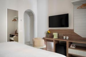 a bedroom with a bed and a tv on a wall at Palazzo Tasso in Sorrento