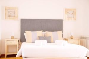 a bedroom with a large white bed with two night stands at Vila da Praia 462-C01 in Óbidos +29 photos