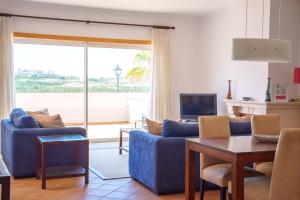 a living room with a blue couch and a table at Vila da Praia 462-C01 in Óbidos