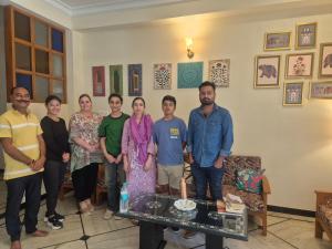 a group of people posing for a picture in a room at Arti's Homestay in Agra