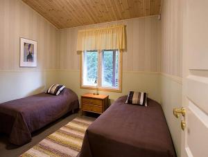 a bedroom with two beds and a window at PUUSTILANRANTA 4 A (5 mh) in Tahkovuori