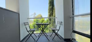 two chairs and a table on a balcony with a window at Golf Course Frontage House in Schofields