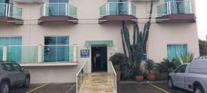 a building with cars parked in front of it at Apartamento de frente ao mar - Centro in Peruíbe