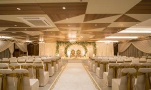 a banquet hall with rows of chairs and a stage at HOTEL SILVERA GRAND in Ahmedabad