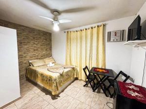 a bedroom with a bed and a brick wall at Suítes em Bacaxá Saquarema in Saquarema
