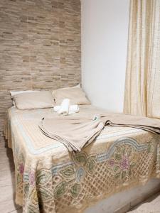 a bed with a blanket and two stuffed animals on it at Suítes em Bacaxá Saquarema in Saquarema