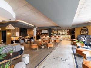 eine Hotellobby mit Tischen und Stühlen in der Unterkunft Mercure Luxembourg Off Kirchberg in Luxemburg (Stadt) + 57 Fotos